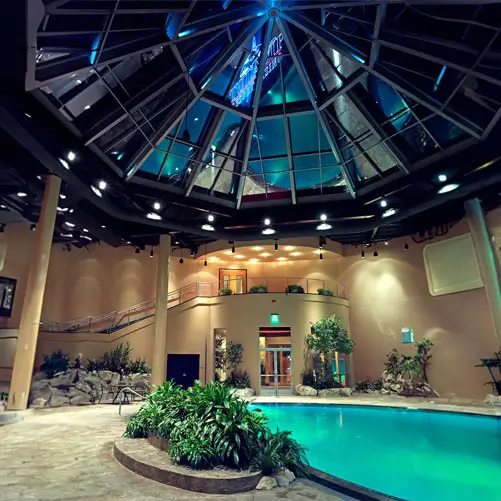 hotel with indoor pool, view of the pool and the stairs down from the second floor.